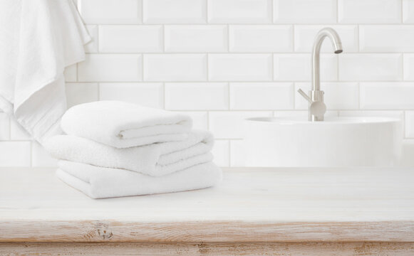 Stack of fresh towels on table in bathroom with space