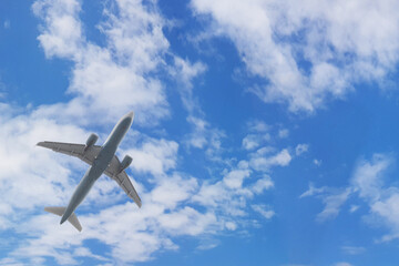 Flying plane in blue sky with clouds on white background