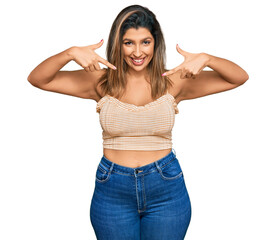 Fototapeta premium Beautiful brunette woman wearing casual clothes looking confident with smile on face, pointing oneself with fingers proud and happy.
