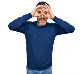 Middle age hispanic man wearing casual clothes doing ok gesture like binoculars sticking tongue out, eyes looking through fingers. crazy expression.