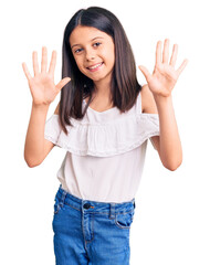 Beautiful child girl wearing casual clothes showing and pointing up with fingers number ten while...