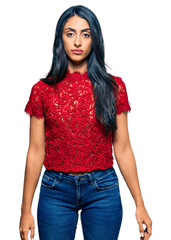 Beautiful hispanic woman wearing elegant shirt with serious expression on face. simple and natural looking at the camera.