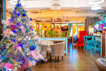 Christmas decorations in the interior. Festive background. New Year's room design, beautiful and shiny toys on the Christmas tree. Blurred background with copy space for text.