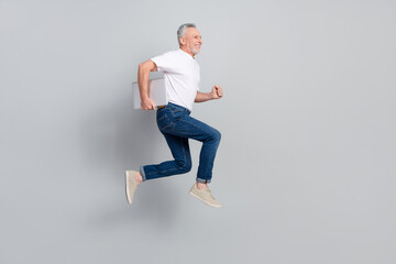 Full length body size view of handsome cheerful successful man jumping running isolated over grey...