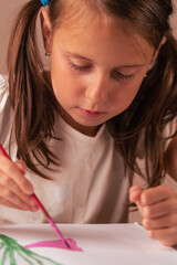 Portrait of beautiful young child girl painting with brush. Vertical image.