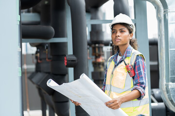 Woman engineer working with construction building blueprint at sewer pipes area at construction...