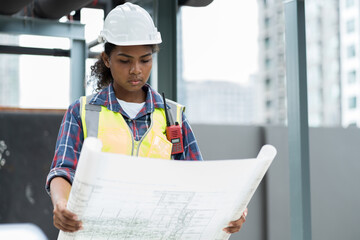 Woman engineer working with construction building blueprint at sewer pipes area at construction...