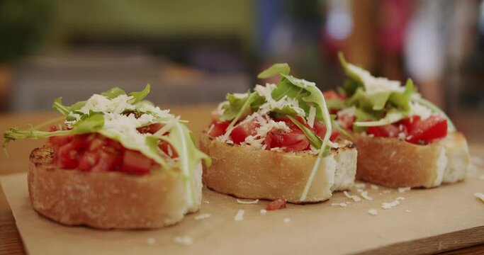 Delicious bruschetta sourdough toast with cherry tomatoes, cheese and arugula. traditional italian breakfast brunch, Healthy food and dieting concept. Italian Bruschetta crostini. Healthy, vegan food.
