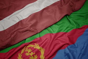waving colorful flag of eritrea and national flag of latvia.