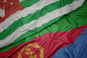 waving colorful flag of eritrea and national flag of abkhazia.