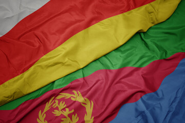 waving colorful flag of eritrea and national flag of south ossetia.