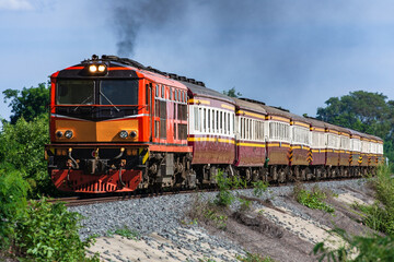 Fototapeta premium Passenger train by diesel locomotive on the railway in Thailand