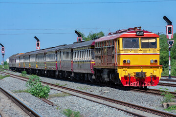Fototapeta na wymiar Passenger train by diesel locomotive on the railway in Thailand