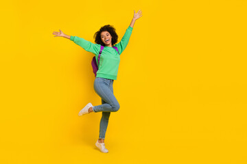 Fototapeta na wymiar Full length portrait of satisfied carefree girl raise opened hands have fun isolated on yellow color background