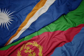 waving colorful flag of eritrea and national flag of Marshall Islands .