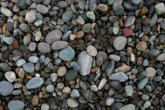 Pebble beach stones background, natural rounded gravel on the seashore nature background texture pattern