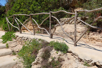 Cala en Forcat, Menorca (Minorca), Spain. Path through the pines and typical Menorcan fencing system made with crossed wooden parts