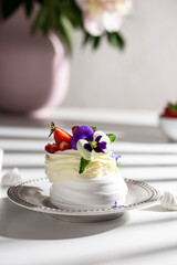 Obraz na płótnie Canvas Meringue dessert with berries and flowers for breakfast