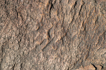 Raw granite rock texture background. Fragment of natural stone wall.