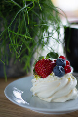 Dessert Pavlova - close-up. Morning breakfast in a cafe with a delicate dessert with cheese cream and fresh berries.