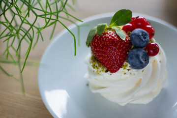Dessert Pavlova with berry - top view. Morning breakfast in a cafe with a delicate dessert with cheese cream and fresh berries.