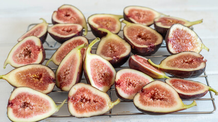 Cut up fig fruits on a metal drying rack.