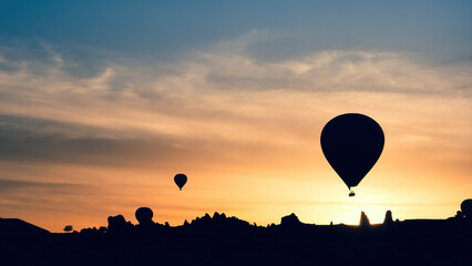 Hot air balloon silhouettes in mountains at sunrise, Goreme, Cappadocia, Turkey