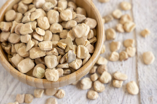 Bowl of raw dry Grass pea close up on wooden table. Legumes known in Italy as Cicerchia