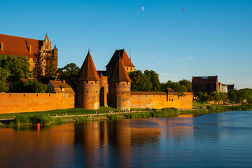 Obraz premium Marienburg Castle the largest medieval brick castle in the world in the city of Malbork at sunset