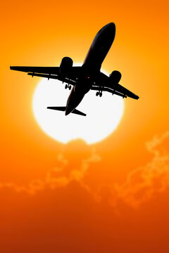 passenger plane silhouette Taking off from the airport. Passenger plane in the sky at sunrise or sunset. Vacation and travel concept. Toned image