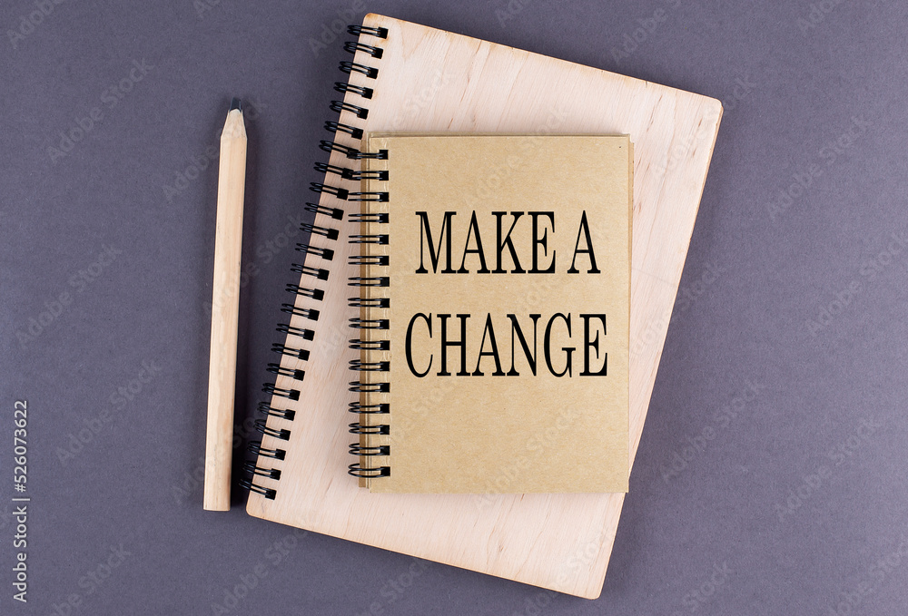 Poster word make a change a notebook with pencil on the grey background