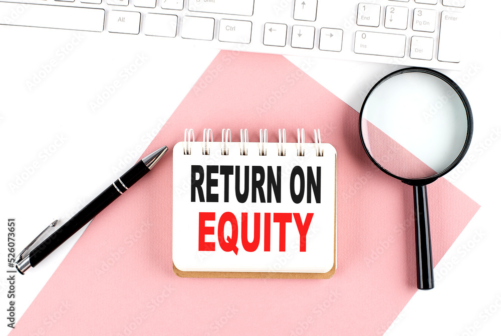 Poster business concept. notebook with text return on equity on pink paper with magnifier, keyboard and pen