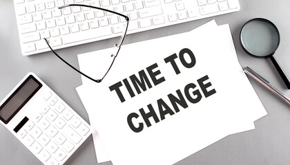 TIME TO CHANGE text on paper with keyboard, calculator on grey background