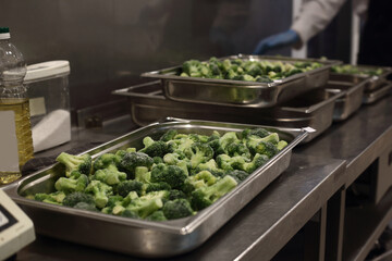 hotel pans of broccoli on the kitchen of a restaurant