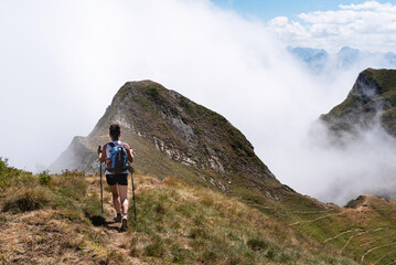Female hiker walking on a Pyrenean ridge in the fog