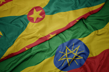 waving colorful flag of ethiopia and national flag of grenada.