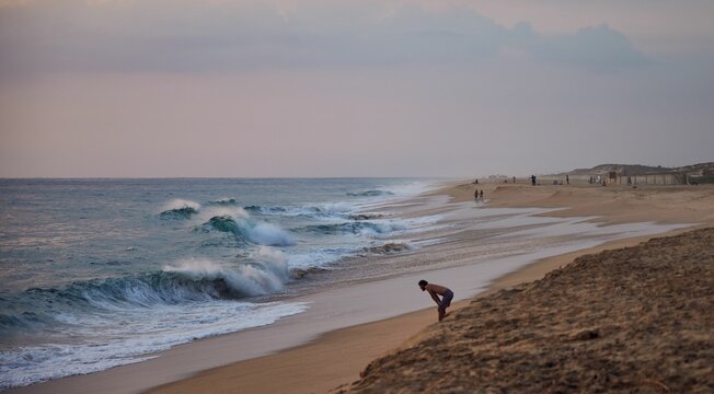 Man Leaning Forward On The Seashore