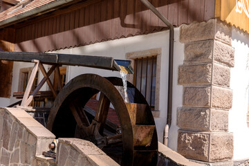 Old rusty water wheel of the restored mill at the house