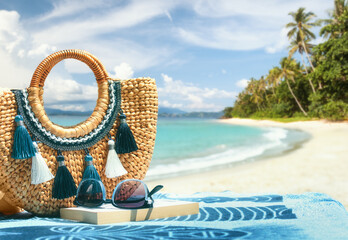 Tropical beach summer holiday accessories, with blurred beach palm trees and sea in background.