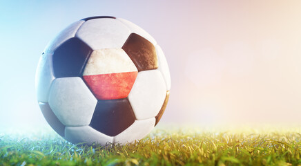 Football soccer ball with flag of Poland on grass