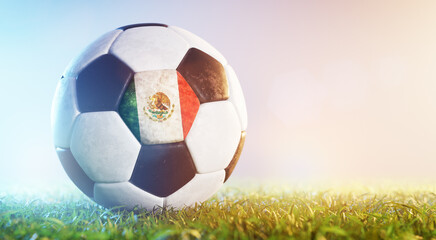 Football soccer ball with flag of Mexico on grass