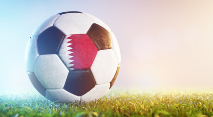 Fototapeta na wymiar Football soccer ball with flag of Quatar on grass