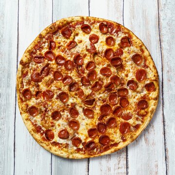 Top View Shot Of A Pepperoni Pizza On A Wooden Background