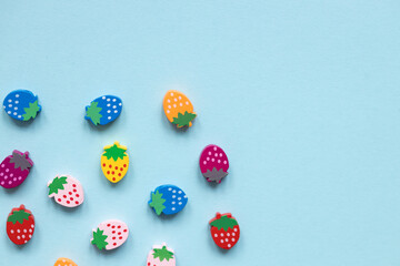 Fototapeta na wymiar Colored wooden figures in the form of strawberries on a blue background