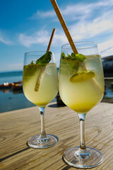 Hugo, cocktail on table with the Ammersee in the background