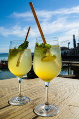 Hugo, cocktail on table with the Ammersee in the background