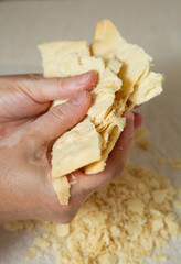 Making homemade Napoleon cake. One layer is broken into small pieces for sprinkling the cake
