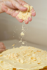 Making homemade Napoleon cake. The cake is sprinkled liberally with crumbs on top