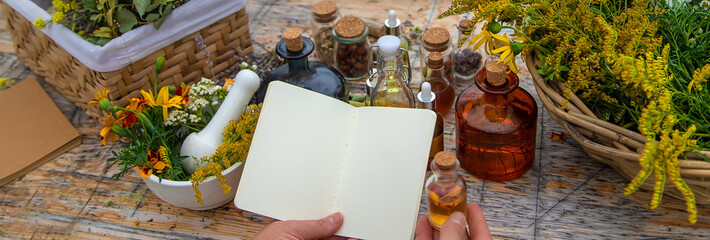 Medicinal herbs on the table. Place for notepad text. woman. Selective focus.