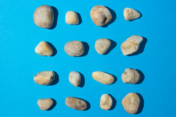 Fototapeta na wymiar White stones stacked in rows on a blue background. subject photography